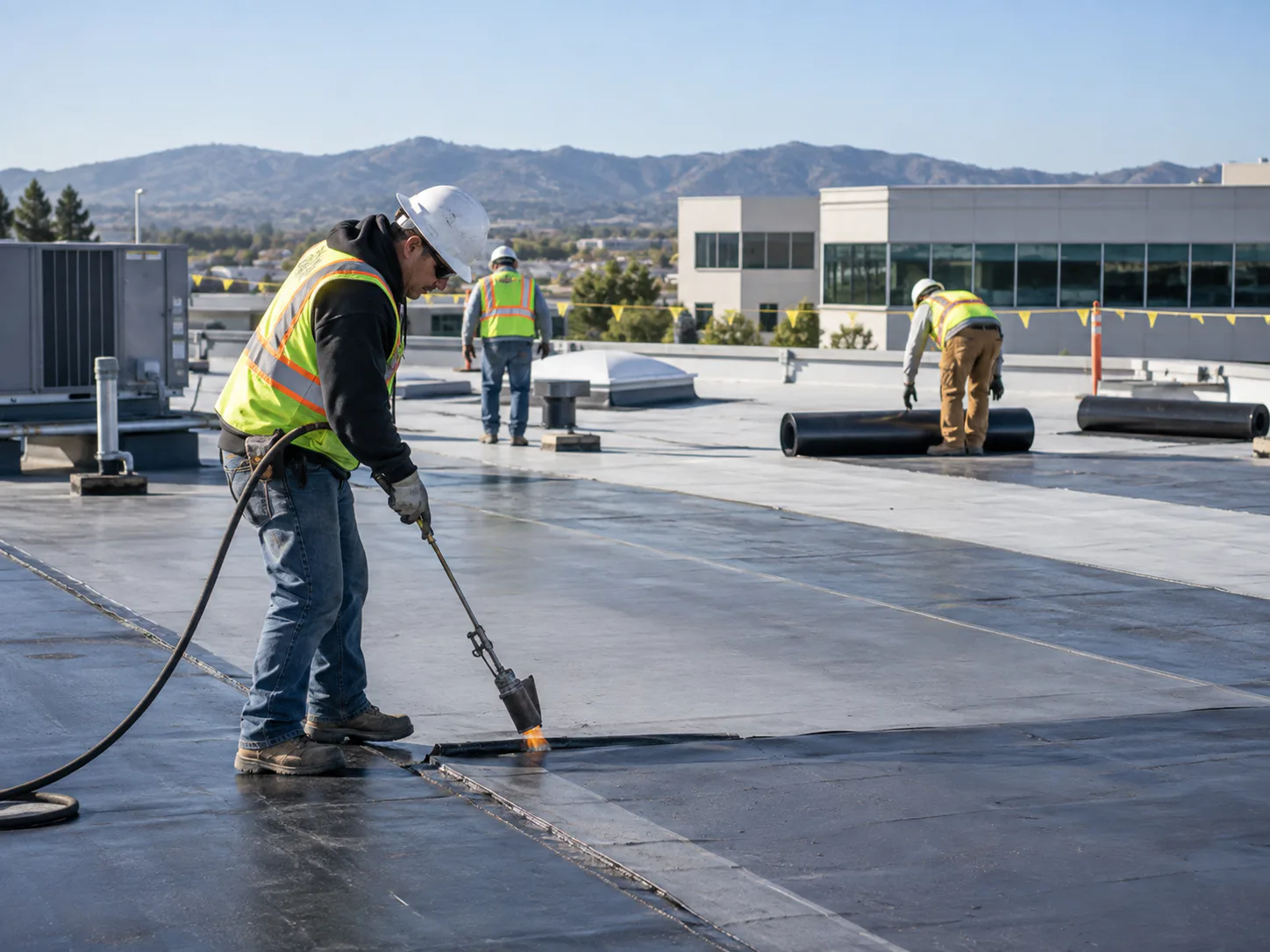 Roofing professionals working on a commercial roof
